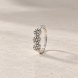 THREE-ROSETTE RING WITH ILLUSION-SETTING DIAMONDS IN PRONGS