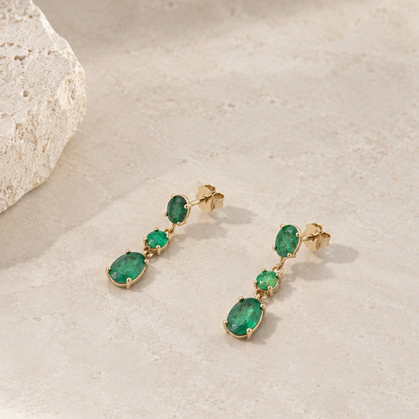 Long earrings with oval and round emeralds